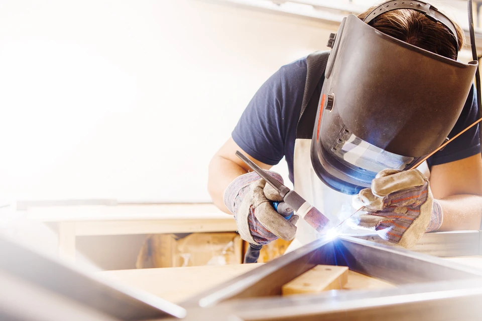 Un soudeur professionnel travaille sur une structure métallique dans un atelier