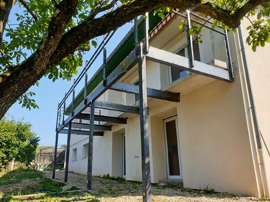 Structure métallique en acier galvanisé formant une terrasse/balcon en porte-à-faux fixée sur façade de maison individuelle blanche