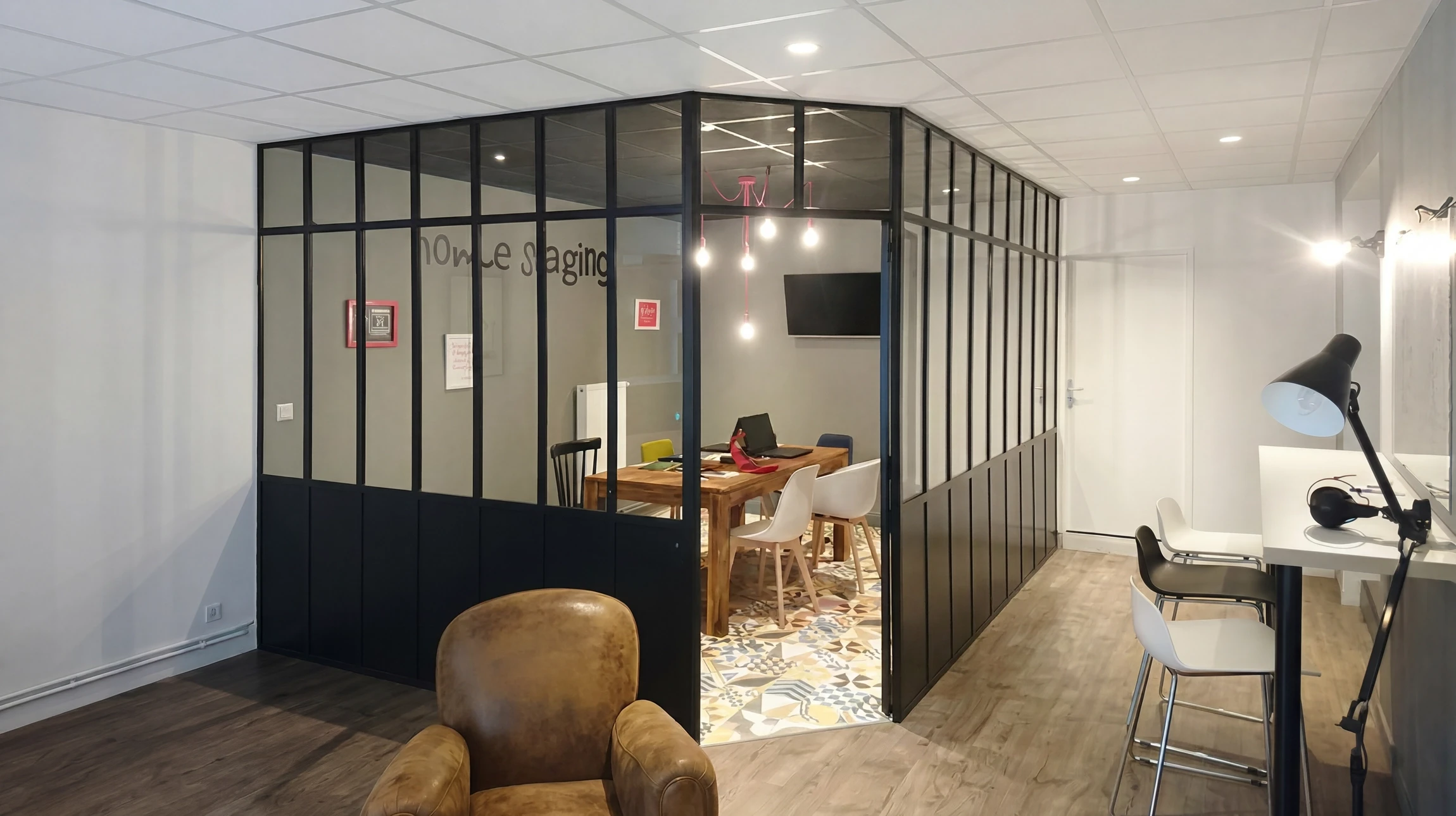 Photographie réaliste en haute qualité d'un intérieur résidentiel moderne montrant une verrière métallique élégante en acier ou aluminium noir mate, avec encadrements fins, créant une séparation entre un espace cuisine-séjour ouvert. La verrière laisse passer la lumière naturelle, révélant des espaces intérieurs clairs et lumineux. La perspective montre le détail et la finition de la verrière, et capture l'effet de luminosité et la modernité qu'elle apporte à l'intérieur.